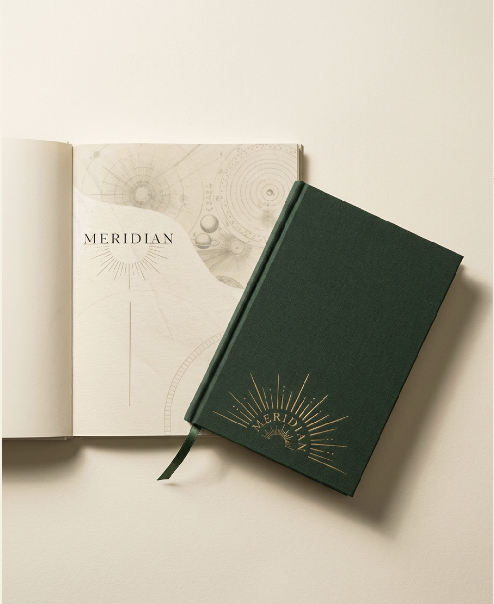 The Meridian planner — a bottle-green cloth hardcover with gold foil sunburst logo, resting slightly askew across its own cream title-page spread